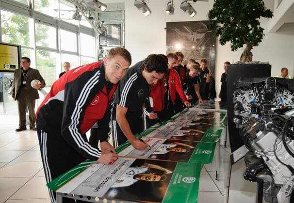 Die Spieler der Nationalmannschaft geben Autogramme und signieren Poster - v.l. Torwart Manuel NEUER, Mats HUMMELS. Werksführung der deutschen Fussball Nationalmannschaft im Motorenwerk von Mercedes-Benz in Bad Cannstatt Stuttgart am 9.8.2011.