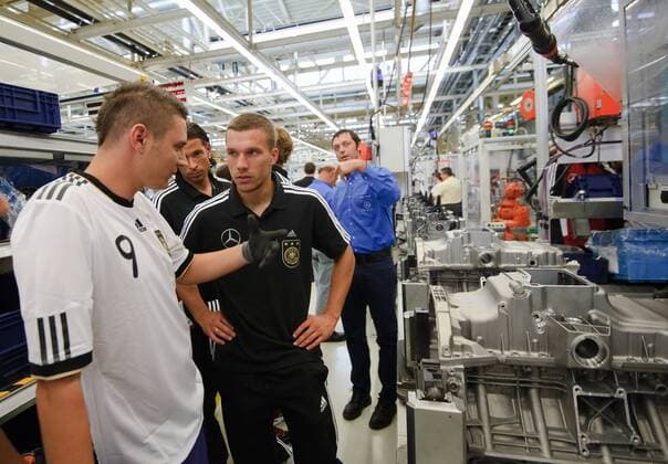 Lukas PODOLSKI (Deutschland)laesst sich die Fertigung am Band von Mercedes-Benz erklaeren. Hinter ihm links: Torwart TIM WIESE (DFB Deutschland). Fussball: Werksfuehrung der deutschen Fussball- Nationalmannschaft der Maenner am 09.08.2011 im Motorenwerk Bad Cannstatt, Stuttgart, 09.08.2011  o00 Wirtschaft Fan