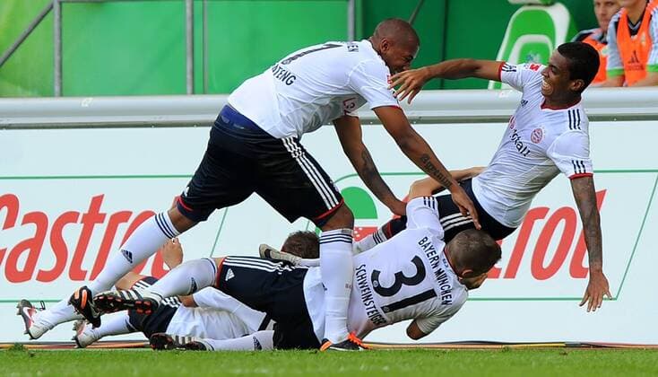 13. August 2011: Wolfsburg, Volkswagen Arena: Fussball 1. Bundesliga, 4. Spieltag: VfL Wolfsburg - FC Bayern München: Münchens Luiz Gustavo (r) jubelt nach seinen Treffer zum 1:0 mit Bastian Schweinsteiger (unten) und Jerome Boateng.