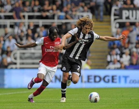 Fabricio Coloccini of Newcastle United (R) holds off Gervinho of Arsenal during the Premier League football match between Newcastle United and Arsenal FC London on 13 August, 2011, at St. James Park, Newcastle upon Tyne, England. Barclays Premier League 2011 EDITORIAL USE ONLY. No use with unauthorised audio, video, data, fixture lists, club league logos or live services. Online in-match use limited to 120 images, no video emulation. No use in betting, games or single club league player publications.