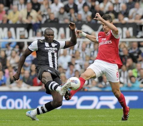 Shola Ameobi of Newcastle United (L) fights for the ball with Laurent Koscielny of Arsenal during the Premier League football match between Newcastle United and Arsenal FC London on 13 August, 2011, at St. James Park, Newcastle upon Tyne, England. Barclays Premier League 2011 EDITORIAL USE ONLY. No use with unauthorised audio, video, data, fixture lists, club league logos or live services. Online in-match use limited to 120 images, no video emulation. No use in betting, games or single club league player publications.