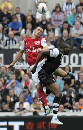 Shola Ameobi of Newcastle United (R) fights for the ball with Thomas Vermaelen of Arsenal during the Premier League football match between Newcastle United and Arsenal FC London on 13 August, 2011, at St. James Park, Newcastle upon Tyne, England. Barclays Premier League 2011 EDITORIAL USE ONLY. No use with unauthorised audio, video, data, fixture lists, club league logos or live services. Online in-match use limited to 120 images, no video emulation. No use in betting, games or single club league player publications.