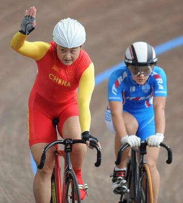 Guo Shuang (L) of China waves to audience after women s sprint final match of cycling track at the 26th Summer Universiade in Shenzhen, a city of south China s Guangdong Province, on Aug. 18, 2011. Guo won the gold medal in the match. (Xinhua Li Ga)(wx) CHINA-SHENZHEN-UNIVERSIADE-CYCLING TRACK-WOMEN S SPRINT (CN) 