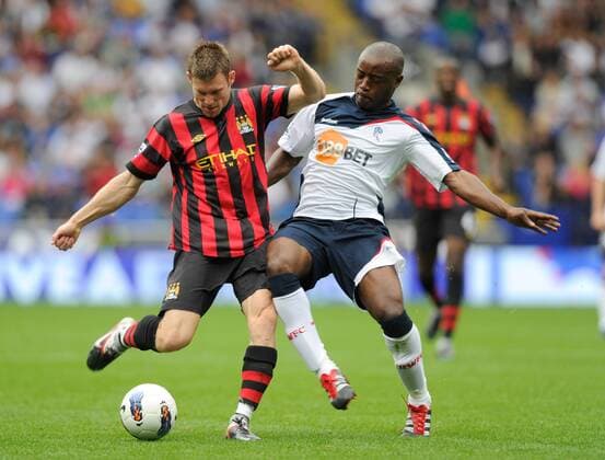 James Milner of Manchester City tackled by Nigel Reo Coker of Bolton Wanderers Barclays Premier League. Bolton Wanderers vs Manchester City 21st August, 2011 EDITORIAL USE ONLY. No use with unauthorised audio, video, data, fixture lists, club league logos or live services. Online in-match use limited to 120 images, no video emulation. No use in betting, games or single club league player publications.