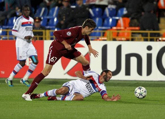 ITAR-TASS: KAZAN, RUSSIA. AUGUST 24, 2011. Russian FC Rubin Kazanâ€™s Solomon Kvirkvelia and French FC Lyonâ€™s Lisandro Lopez (front, L-R) struggle for the ball in their UEFA Champions League game at Central Stadium in the city of Kazan.  RE0ECA44