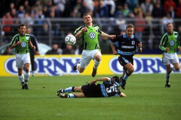 Steffen Baumgart (VfL Wolfsburg, obenauf) gegen Gerald Vanenburg (u.) und Horst Heldt (beide TSV 1860 München)