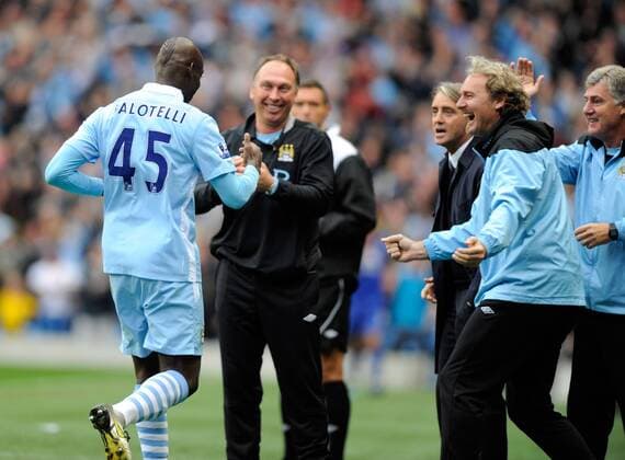 Mario Balotelli of Manchester City runs to hug Roberto Mancini manager of Manchester City after scoring the first goal Barclays Premier League Manchester City v Everton 24th September, 2011 EDITORIAL USE ONLY. No use with unauthorised audio, video, data, fixture lists, club league logos or live services. Online in-match use limited to 120 images, no video emulation. No use in betting, games or single club league player publications.
