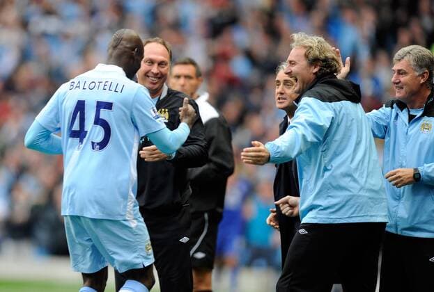 Mario Balotelli of Manchester City celebrates with the Manchester City coaching staff Barclays Premier League Manchester City v Everton 24th September, 2011 EDITORIAL USE ONLY. No use with unauthorised audio, video, data, fixture lists, club league logos or live services. Online in-match use limited to 120 images, no video emulation. No use in betting, games or single club league player publications.