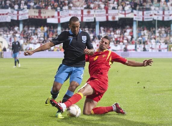 Theo Walcott of England tackled by Milan Jovanovic of Montenegro European Championship Qualifying Group G Montenegro v England 7th October, 2011 EDITORIAL USE ONLY. No use with unauthorised audio, video, data, fixture lists, club league logos or live services. Online in-match use limited to 120 images, no video emulation. No use in betting, games or single club league player publications. Euro