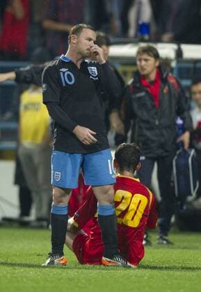 Wayne Rooney of England shows regret as Miodrag Dzudovic of Montenegro sits on the ground following his tackle European Championship Qualifying Group G Montenegro v England 7th October, 2011 EDITORIAL USE ONLY. No use with unauthorised audio, video, data, fixture lists, club league logos or live services. Online in-match use limited to 120 images, no video emulation. No use in betting, games or single club league player publications. o0 rote Karte o00 Euro
