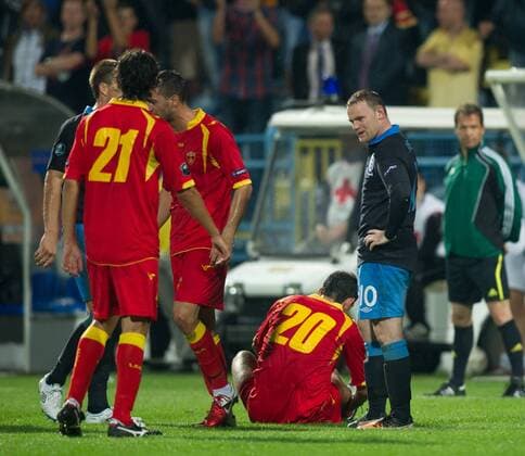Wayne Rooney of England shows regret as Miodrag Dzudovic of Montenegro sits on the ground following his tackle European Championship Qualifying Group G Montenegro v England 7th October, 2011 EDITORIAL USE ONLY. No use with unauthorised audio, video, data, fixture lists, club league logos or live services. Online in-match use limited to 120 images, no video emulation. No use in betting, games or single club league player publications. o0 rote Karte o00 Euro