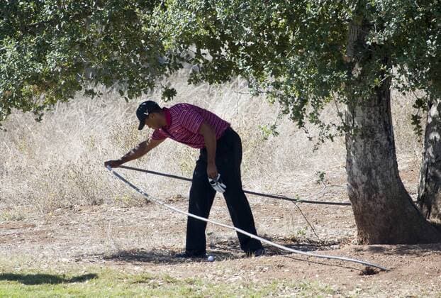Oct. 9, 2011 - San Martin, CA, USA - Tiger Woods moves a cable after he hit his tee shot under a tree on the 5th hole during the final round of the Frys.com Open golf tournament at the CordeValle golf course in San Martin, California, Sunday, October 9, 2011. Frys Open - ZUMAm67