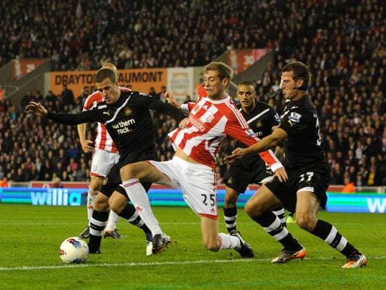 Peter Crouch of Stoke City stretches for the ball as Ryan Taylor of Newcastle United and Steven Taylor of Newcastle United close him down, Stoke City - Newcastle United, Stoke on Trent EDITORIAL USE ONLY. No use with unauthorised audio, video, data, fixture lists, club league logos or live services. Online in-match use limited to 120 images, no video emulation. No use in betting, games or single club league player publications.