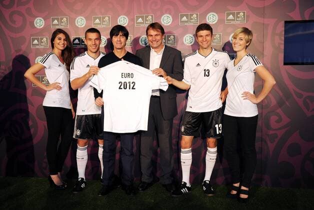 FUSSBALL DEUTSCHE NATIONALMANNSCHAFT SAISON 2011 2012 Lukas PODOLSKI, Trainer Joachim LÖW, Günther WEIGL (Adidas) und Thomas MÜLLER (v.l., alle Deutschland) präsentieren das neue Trikot der Nationalmannschaft am 09.11.2011 in Hamburg  o0 Vorschau EM Wirtschaft Ausrüster Euro 2012
