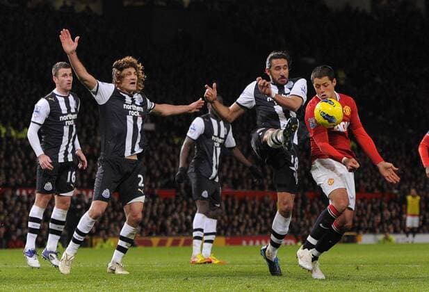 Jonas Gutierrez of Newcastle United clears as Javier Chicharito Hernandez of Manchester United closes in Barclays Premier League Manchester United v Newcastle United 26th November, 2011 EDITORIAL USE ONLY. No use with unauthorised audio, video, data, fixture lists, club league logos or live services. Online in-match use limited to 120 images, no video emulation. No use in betting, games or single club league player publications.