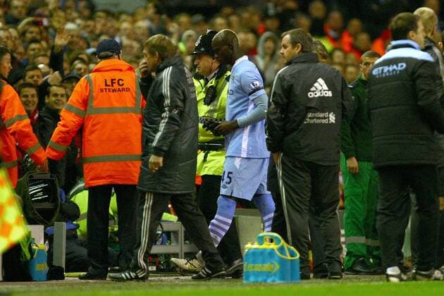 Football - Premier League - Liverpool vs. Manchester City Mario Balotelli of Manchester City is led away down the tunnel by a police officer following his red card at Anfield 