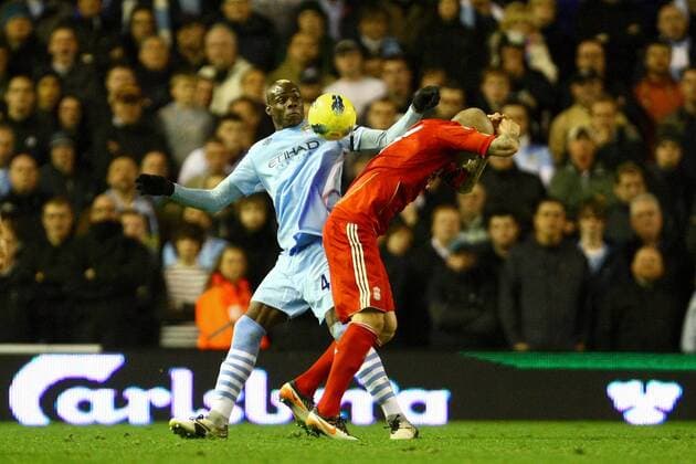 Football - Premier League - Liverpool vs. Manchester City Mario Balotelli of Manchester City makes contact with his elbow on the back of Martin Skrtel of Liverpool to earn a red card at Anfield 
