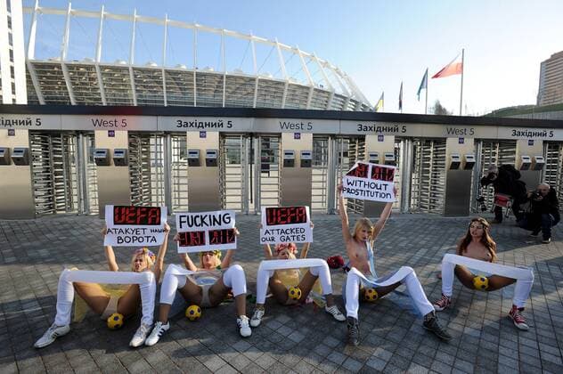 Protest der ukrainischen Frauengruppe FEMEN gegen die geplanten staatlichen Verhaltensvorschriften während der Fussball-Europameisterschaft 2012, vor dem Olympia-Stadion in Kiew, halten Transparente hoch mit Protestparolen, am 02.12.2011 in Kiew Ukraine