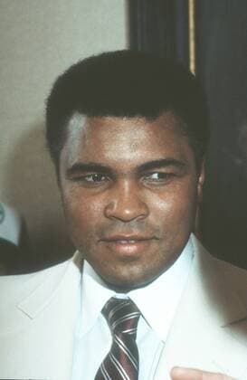 Muhammad Ali (Ex-Boxprofi) 09 84 wot Mann ehemaliger Boxer Box-Profi Profi-Sport Profisport Boxen Weltmeister Boxweltmeister dunkelhäutig dunkelhaarig kurzhaarig seriös Jackett Hemd weiss Krawatte stehend Saal Halle Portrait hoch lächelnd zur Seite schauend Cassius Clay