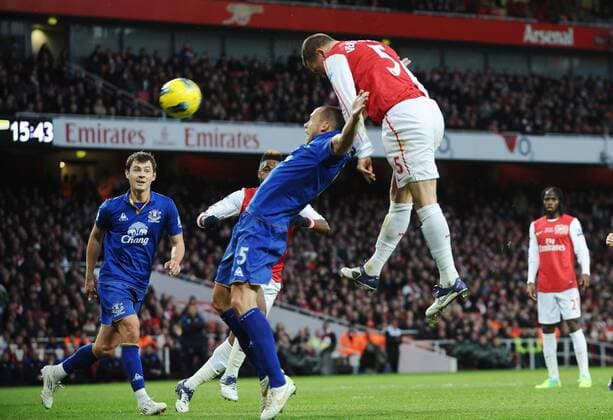 Football - Premier League - FC Arsenal vs. FC Everton Emirates stadium Thomas Vermaelen (FC Arsenal) outjumps John Heitinga 