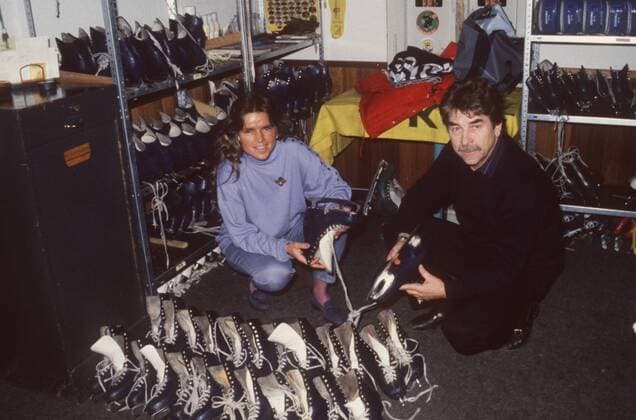 Jupp Kompalla mit Tochter Nicole (Schiedsrichter Eishockey) 01 89 hör Sport sportlich Eishalle Garderobe Umkleide Schlittschuhe Schlittschuh Regal Hockey quer ganz lächelnd hockend