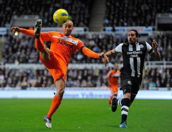 Ashley Richards of Swansea City FC (L) clears the ball ahead of Jonas Gutierrez of Newcastle United during the Premier League football match between Newcastle United and Swansea City on 17 December 2011, at Sports Direct Arena, Newcastle upon Tyne, England. EDITORIAL USE ONLY. No use with unauthorised audio, video, data, fixture lists, club league logos or live services. Online in-match use limited to 120 images, no video emulation. No use in betting, games or single club league player publications.