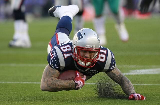 New England Patriots tight end Aaron Hernandez (81) dives into the turf after being tripped up on a ten yard reception in the third quarter against the Miami Dolphins at Gillette Stadium in Foxboro, Massachusetts on December 24, 2011. The Patriots defeated the Dolphins 27-24.  BOS2011122416