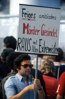 Protestler mit Plakat während der Trauerfeier anlässlich des Attentats palästinensischer Terroristen auf das israelische Olympiateam während der Olympischen Spiele 1972 in München