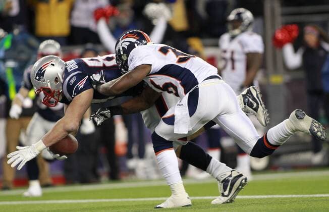 New England Patriots tight end Rob Gronkowski (87) dives into the end zone past Denver Broncos safety Rafael Bush (36) on a 12-yard touchdown reception in the second quarter of the AFC divisional playoff game at Gillette Stadium in Foxboro, Massachusetts on January 14, 2012.  BOS2012011410