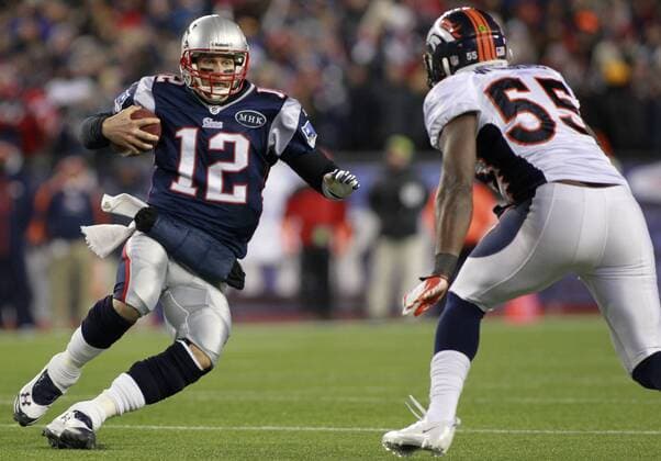 New England Patriots quarterback Tom Brady (12) slides on a two-yard carry before being tackled by Denver Broncos linebacker D.J. Williams in the second quarter at Gillette Stadium in Foxboro, Massachusetts on January 14, 2012. The Patriots defeated the Broncos 45-10.  BOS2012011424