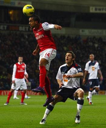 Football - Premier League - Bolton Wanderers vs. FC Arsenal FC Arsenal s Theo Walcott wins a header over Sam Ricketts of Bolton at the Reebok Stadium 