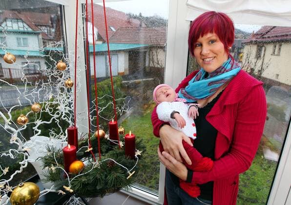 Steinbach-Hallenberg , 141211 , Zu Besuch bei Kati Wilhelm mit ihrer Tochter Lotta in Steinbach-Hallenberg im Bild: Kati Wilhelm (35) mit ihrer schlafenden Tochter Lotta (3 Wochen) im Wintergarten ihrer Eltern in Steinbach-Hallenberg