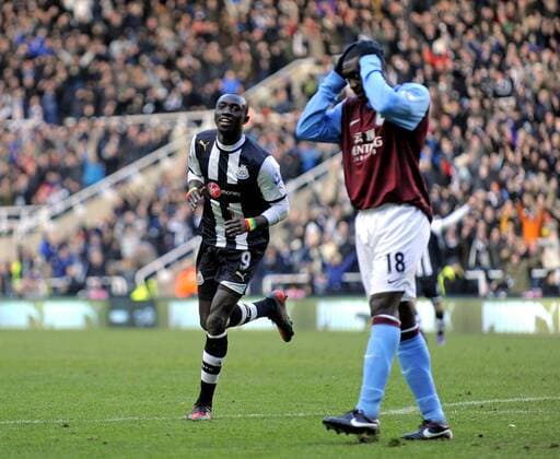 Papiss Demba Cisse of Newcastle United (L) celebrates scoring his side s second goal while Emile Heskey of Aston Villa holds his head dejected .Barclays Premier League match between Newcastle United v Aston Villa at the Sports Direct Arena at Newcastle upon Tyne on 5th February 2012. EDITORIAL USE ONLY. No use with unauthorised audio, video, data, fixture lists, club league logos or live services. Online in-match use limited to 120 images, no video emulation. No use in betting, games or single club league player publications.