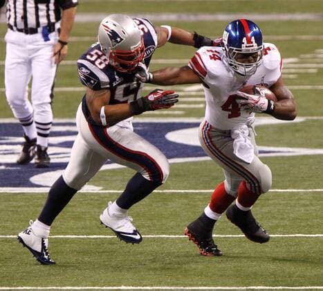 Feb. 5, 2012 - Indianapolis, Indiana, U.S. - Running back AHMAD BRADSHAW (44) of the New York Giants tries to fend off outside linebacker TRACY WHITE (58) of the New England Patriots during the first quarter of Super Bowl XLVI at Lucas Oil Stadium. The Score at the end of the first quarter 9-3 New York Leads. NFL American Football Herren USA 2012 - Super Bowl - ZUMAm67