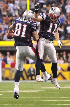 New England Patriots tight end Aaron Hernandez (81) leaps to celebrate his 12-yard touchdown pass reception against the New York Giants with teammate Julian Edelman during the third quarter at Super Bowl XLVI at Lucas Oil Stadium on February 5, 2012 in Indianapolis.  SBP2012020540