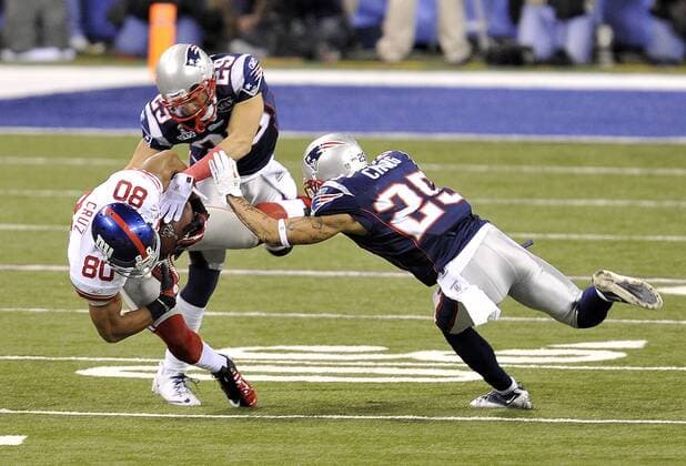 New York Giants wide receiver Victor Cruz, left, makes a catch against New England Patriots free safety Sterling Moore, center and New England Patriots free safety Patrick Chung during Super Bowl XLVI February 5, 2012, in Indianapolis. (UPI Photo Brian Kersey)  SBP20120205998