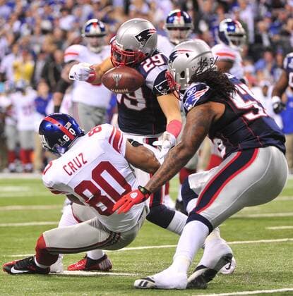 New England Patriots safety Sterling Moore (29) and linebacker Brandon Spikes break up pass intended for New York Giants receiver Victor Cruz during the first quarter at Super Bowl XLVI at Lucas Oil Stadium on February 5, 2012 in Indianapolis. The NFC champion New York Giants play the AFC champion New England Patriots.  SBP20120205333