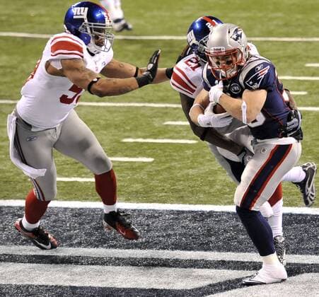 New England Patriots running back Danny Woodhead, right, catches a touchdown pass in front of New York Giants outside linebacker Michael Boley, left and strong safety Kenny Phillips during Super Bowl XLVI February 5, 2012, in Indianapolis. (UPI Photo Brian Kersey)  SBP20120205997