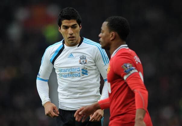 Football - Premier League - Manchester United vs. Liverpool Liverpool s Luis Suarez looks at Patrice Evra of Manchester United at Old Trafford, Manchester 