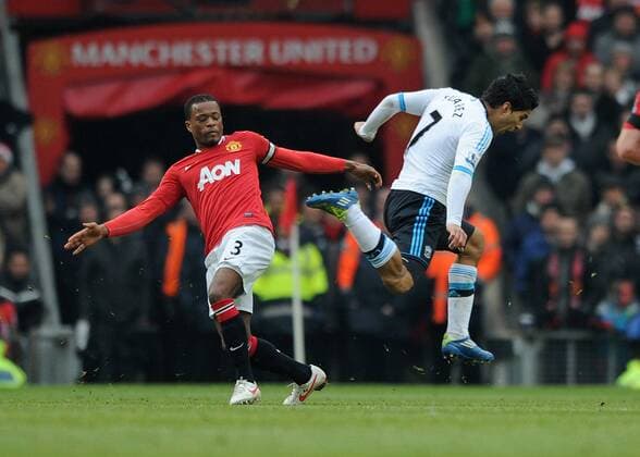 Football - Premier League - Manchester United vs. Liverpool Patrice Evra of Manchester United trips Liverpool s Luis Suarez at Old Trafford, Manchester 