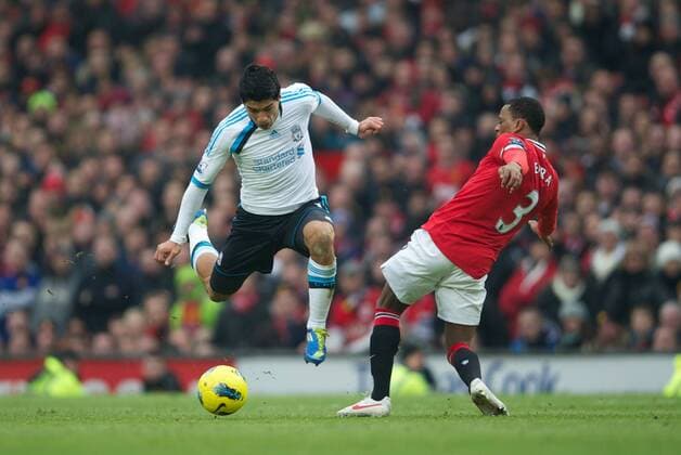 Liverpool s Luis Alberto Suarez Diaz skips past Manchester United s Patrice Evra during the Premiership match at Old Trafford. xHOCHxZWEIx xPropagandax 