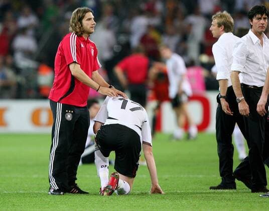 Fussball Herren FIFA WM Weltmeisterschaft 2006 Deutschland - Italien: v.l. Torsten Frings tröstet Per Mertesacker, Trainer Jürgen Klinsmann, Co Joachim Löw enttäuscht