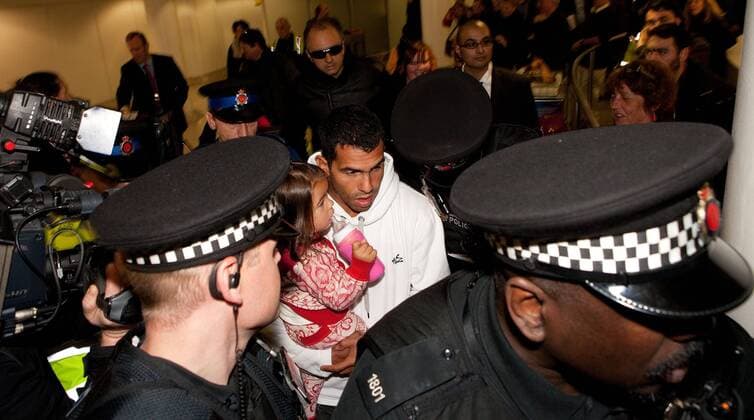 Feb. 14, 2012 - Manchester, England, UK - Carlos Tevez arrives with daughter Katia at Manchester Airport to rejoin the Manchester City squad. He is surrounded by a large media scrum.  - ZUMAl94