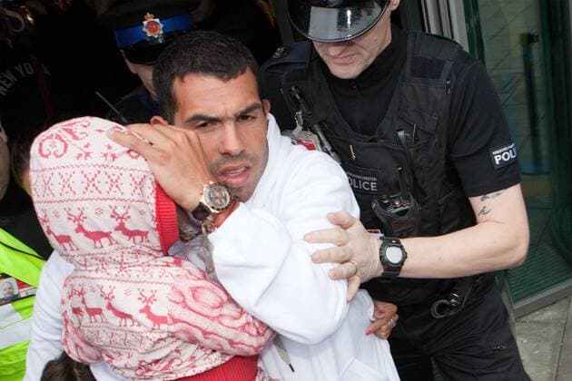Feb. 14, 2012 - Manchester, England, UK - Carlos Tevez arrives with daughter Katia at Manchester Airport to rejoin the Manchester City squad. He is surrounded by a large media scrum.  - ZUMAl94