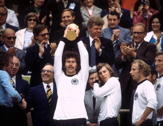 Die BR Deutschland ist Weltmeister 1974 - Paul Breitner präsentiert stolz den Weltpokal, daneben v.re.: Hans Georg Schwarzenbeck, Hans Hubert Berti Vogts, Jürgen Grabowski, Bundeskanzler Helmut Schmidt (SPD), Torwart Sepp Maier (li.) und DFB Präsident Dr. Hermann Gösmann (2.v.li., alle BRD)