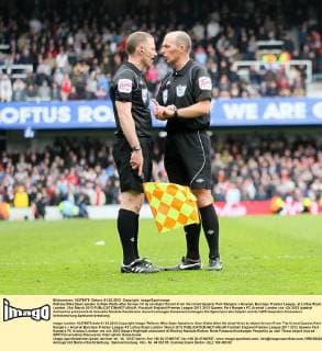 Referee Mike Dean speaks to Alan Watts after he was hit by an object thrown from the crowd Queens Park Rangers v Arsenal, Barclays Premier League, at Loftus Road, London. 31st March 2012 EDITORIAL USE ONLY. No use with unauthorised audio, video, data, fixture lists, club league logos or live services. Online in-match use limited to 120 images, no video emulation. No use in betting, games or single club league player publications.