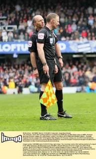 The linesman reacts after getting pelted by an object from QPR fans as Mike Dean looks on QPR v Arsenal, Barclays Premier League, at Loftus Road, London. 31st March 2012 EDITORIAL USE ONLY. No use with unauthorised audio, video, data, fixture lists, club league logos or live services. Online in-match use limited to 120 images, no video emulation. No use in betting, games or single club league player publications.