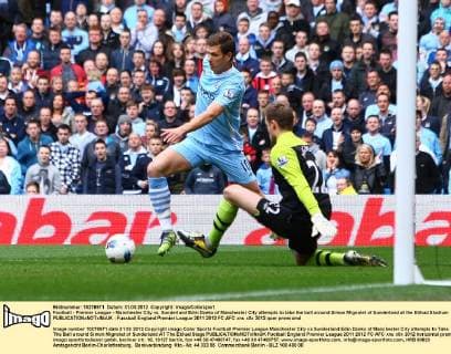Football - Premier League - Manchester City vs. Sunderland Edin Dzeko of Manchester City attempts to take the ball around Simon Mignolet of Sunderland at the Etihad Stadium 