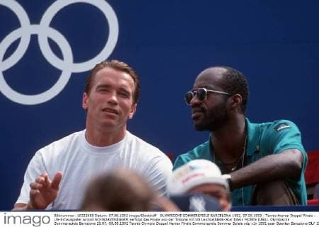 OLYMPISCHE SOMMERSPIELE BARCELONA 1992, 07.08.1992 - Tennis Herren Doppel Finale - US-Schauspieler Arnold SCHWARZENEGGER verfolgt das Finale von der Tribüne mit US Leichtathletik-Star Edwin MOSES (USA). Olympische Sommerspiele Barcelona 25.07.-09.08.1992