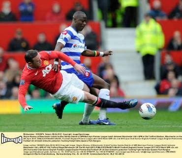 Wayne Rooney of Manchester United tackles Samba Diakite of QPR.Barclays Premier League match between Manchester Utd v QPR at Old Trafford Stadium, Manchester on the 8th April 2012. EDITORIAL USE ONLY. No use with unauthorised audio, video, data, fixture lists, club league logos or live services. Online in-match use limited to 120 images, no video emulation. No use in betting, games or single club league player publications.
